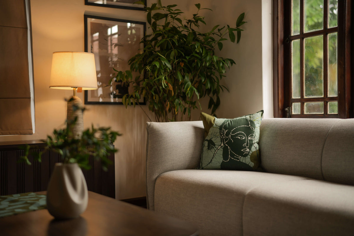 Apsara handmade cotton batik throw pillow in forest green on sage green, 18" x 18", by Kohomba Life on sofa.