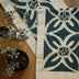 Neelam Flower handmade cotton batik table and bed runner in teal blue on rye, 90" x 14", from Kohomba Life – close-up view. 