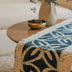 Neelam Flower handmade cotton batik table and bed runner in teal blue on rye, 90" x 14", from Kohomba Life – styled on a dining table.