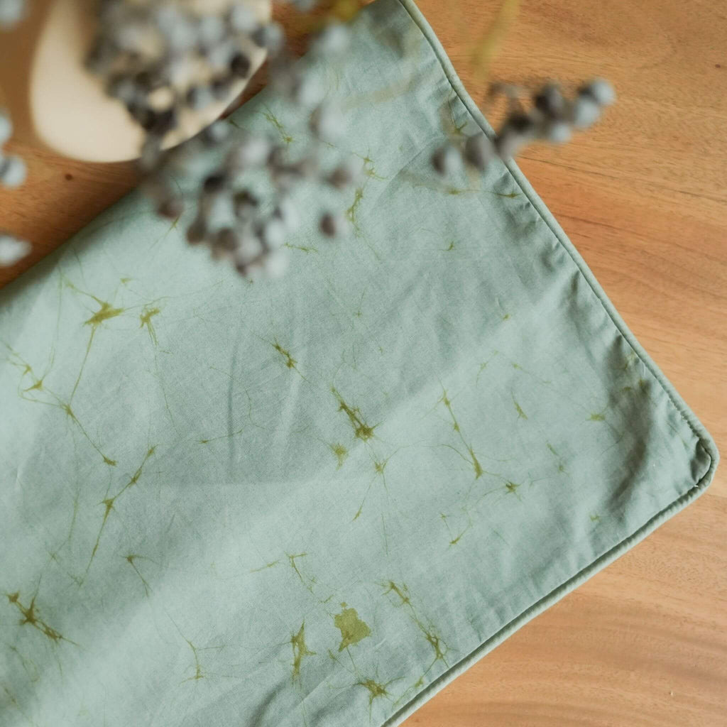 Thaalam handmade cotton batik decorative throw pillow in khaki green on seafoam blue, 18" x 18", by Kohomba Life – close-up view.